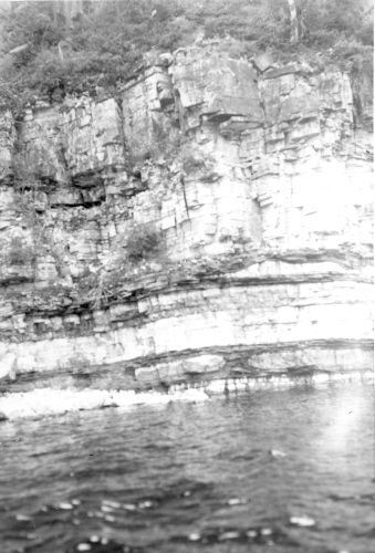 Collection Jacques Rousseau photo - c-606-a-I-1481 -Lac Mistassini. Rivage sud-ouest de  l'?le Manitounouk. Noter les gros noyaux de calcaire plats dans des strates schisteuses alternant avec des strates calcaires.